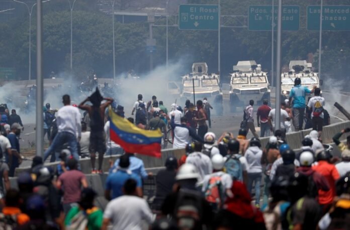 Opposition demonstrators face military vehicles near the Generalisimo Francisco de Miranda Airbase